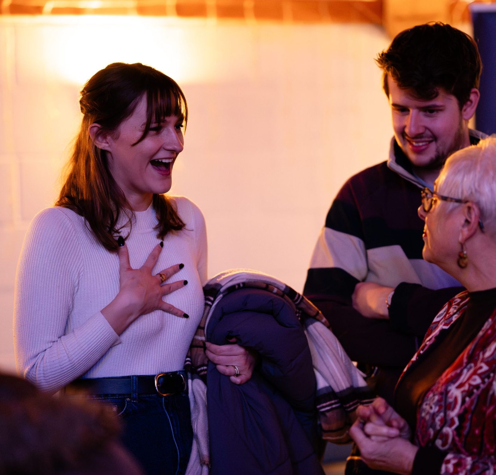 Group of three of various ages at the welcome lounge happily talking