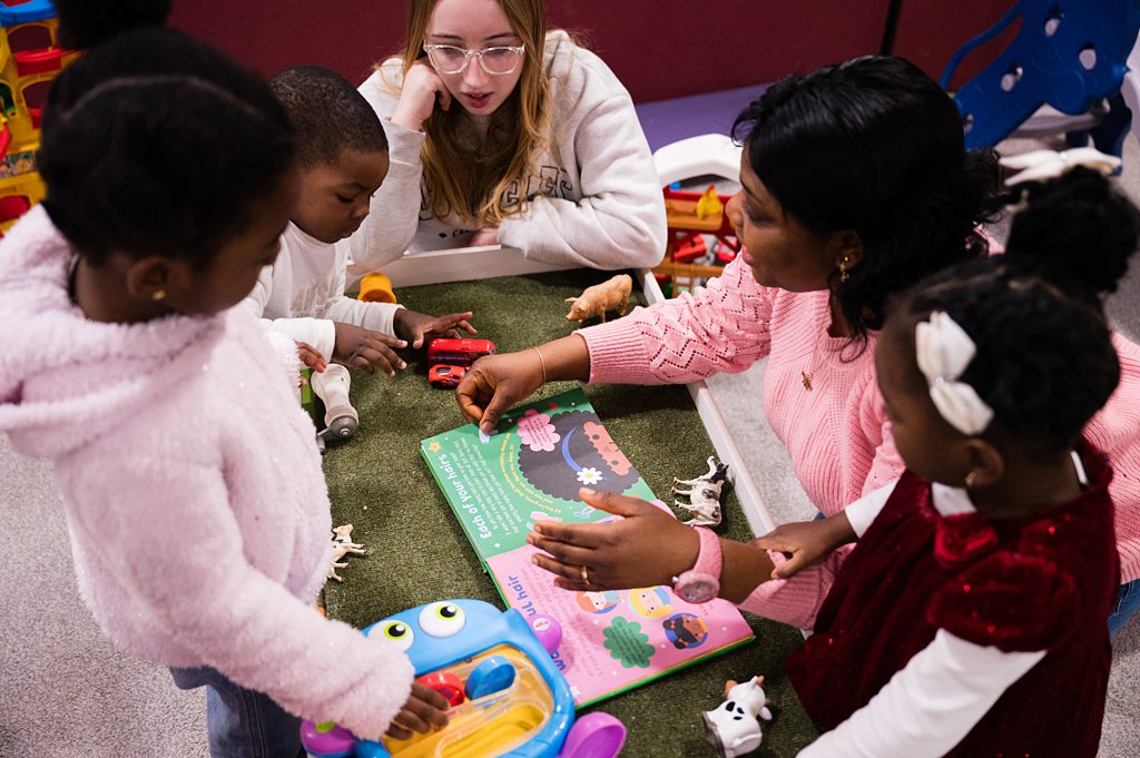 Young children playing games with carers during service