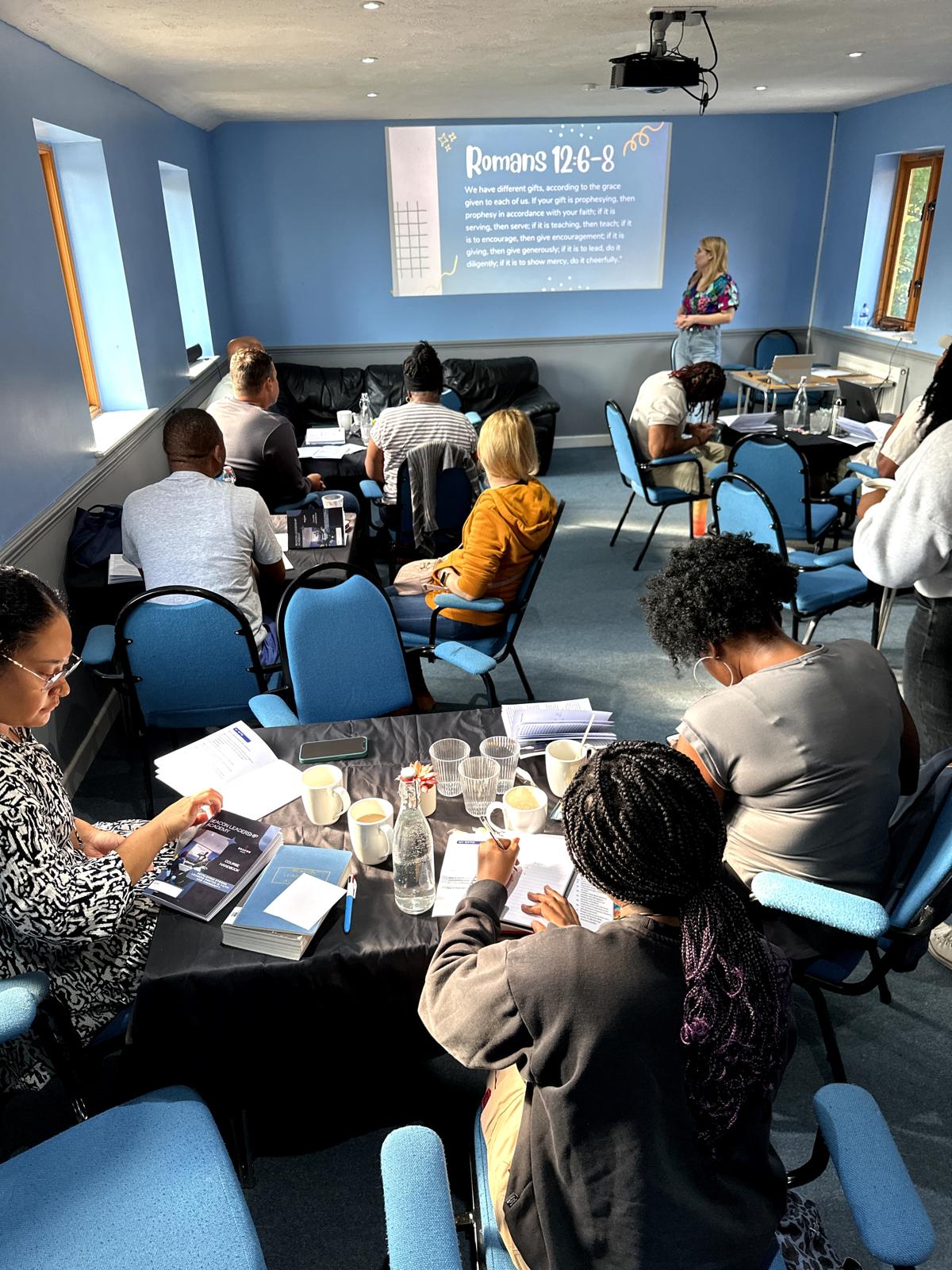 People gathered for a Bible study group, listening to teaching and taking notes at a church in Bury St Edmunds, Suffolk