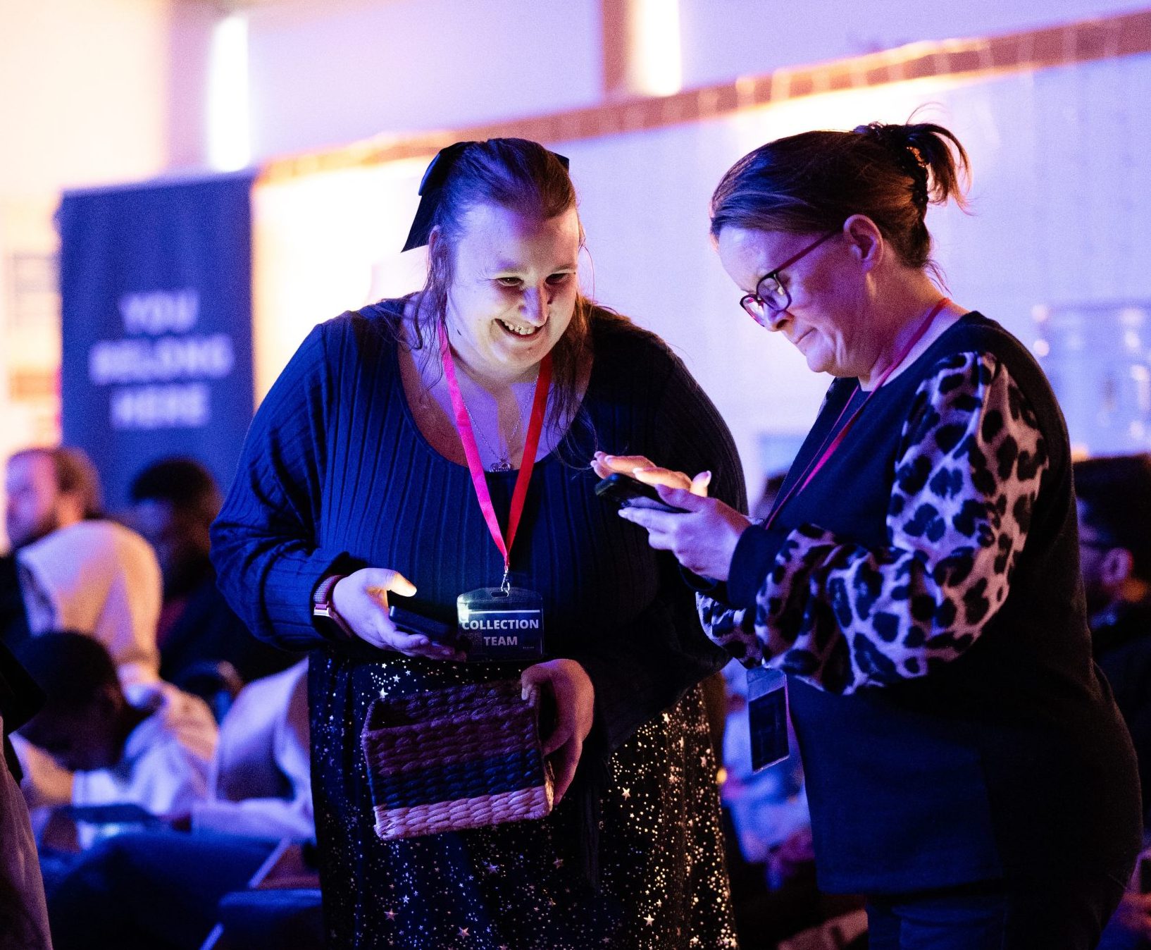 Church collection team members using phones and serving during a service in Bury St Edmunds, Suffolk