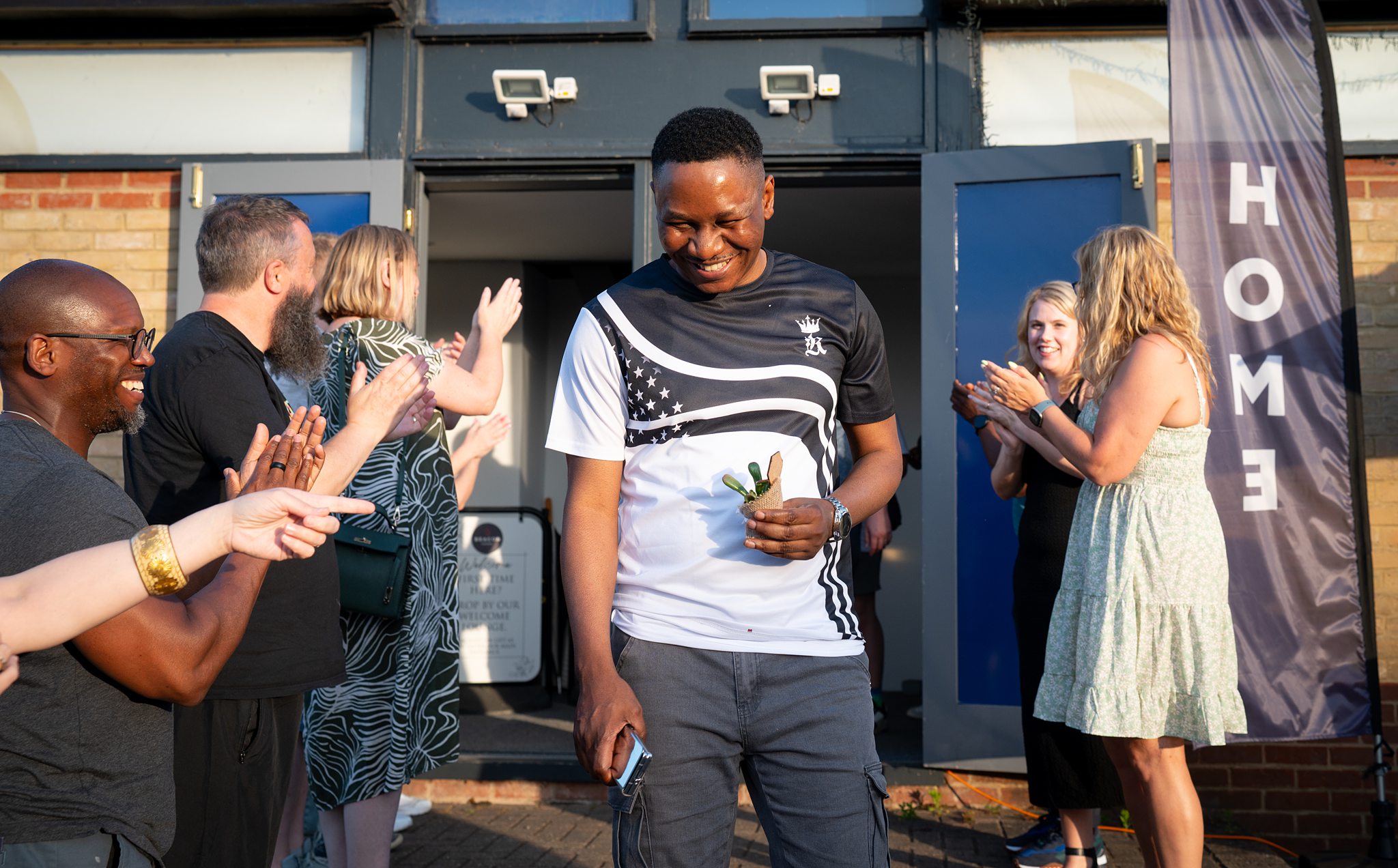 “Man being warmly welcomed with applause outside a church in Bury St Edmunds, Suffolk”