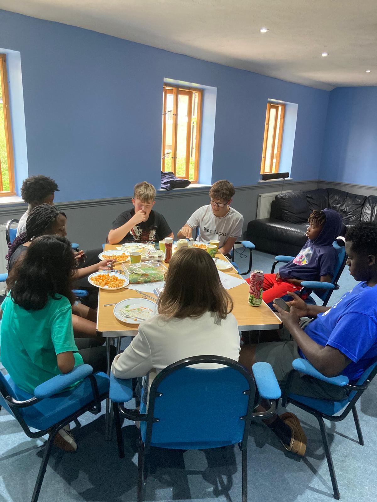Young people gathered around a table sharing food, conversation, and friendship during a Beacon Church youth group session in Bury St Edmunds, Suffolk, building faith, community, and belonging.