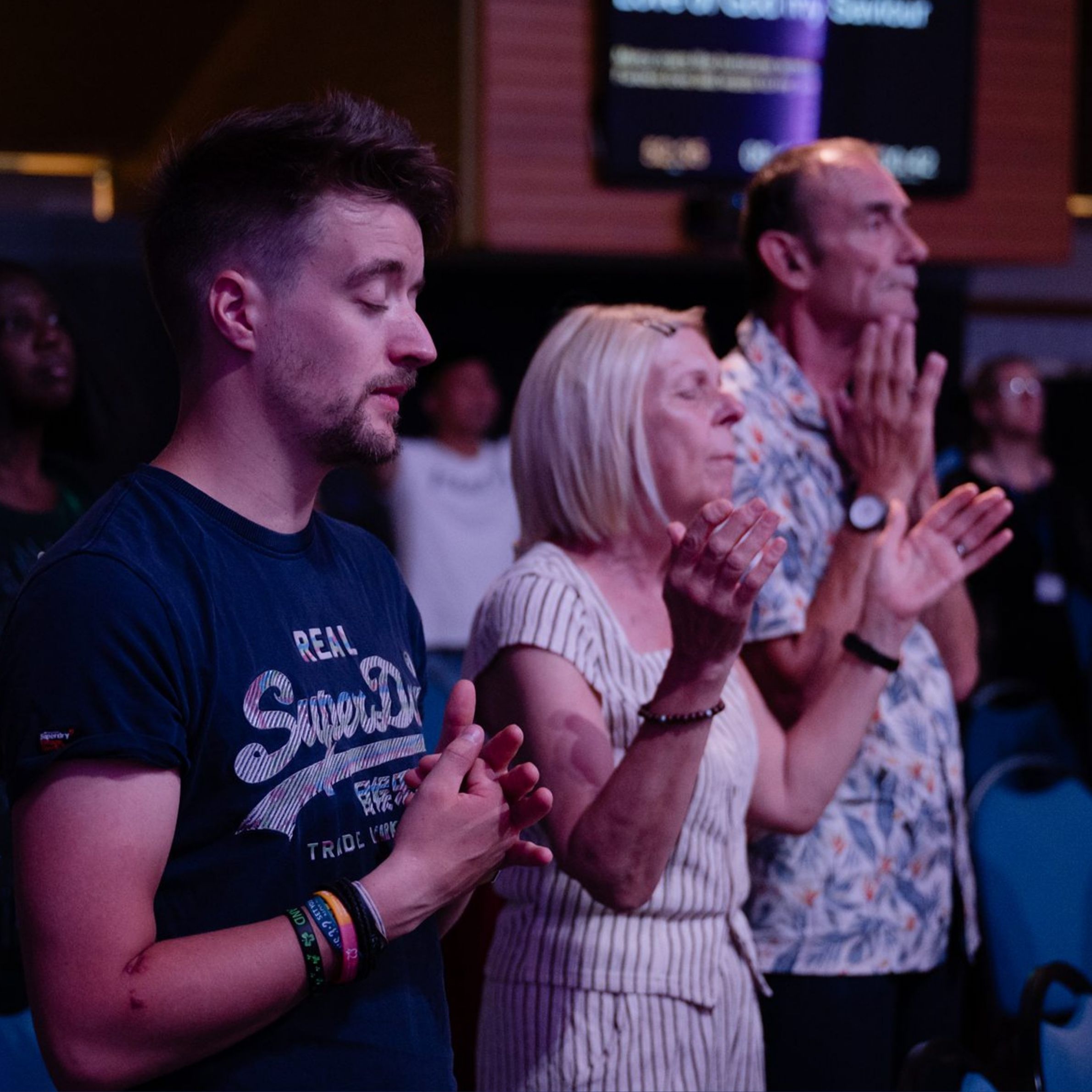 People praying and worshipping together during a service at Beacon Church in Bury St Edmunds, Suffolk.